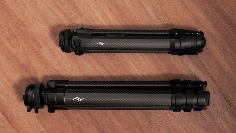 Two black cylindrical camera lens filters or accessories displayed side by side on wood