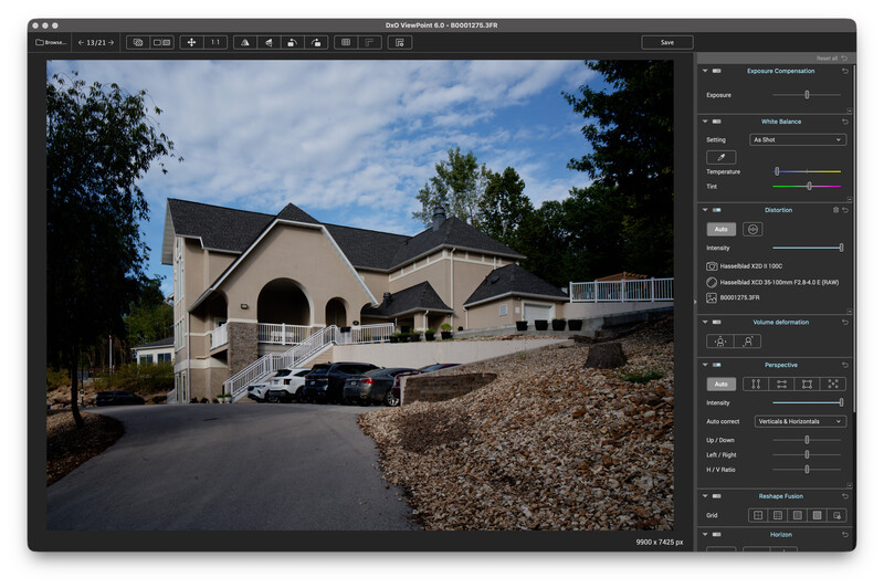 Screenshot of DxO ViewPoint editing a beige stucco building with an arched entrance, dark roof, and parked cars under a blue sky.