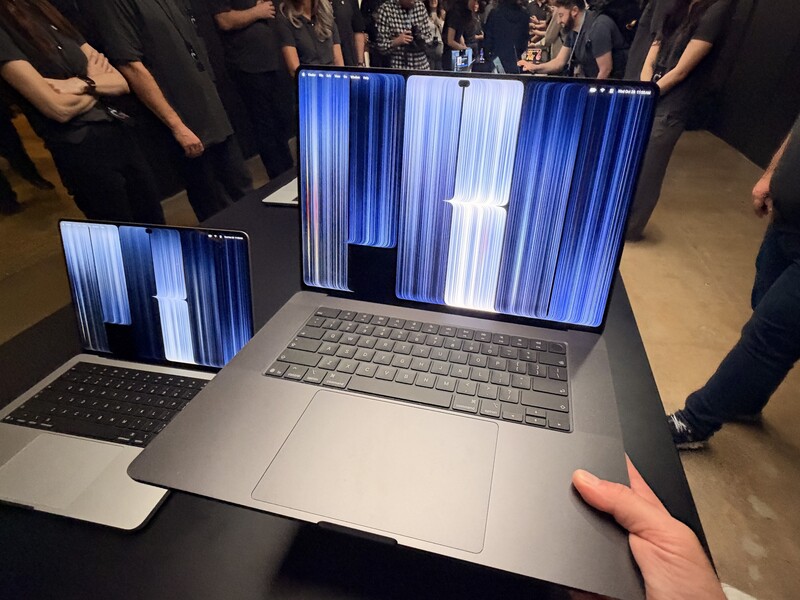 Holding the 16-inch MacBook Pro in the demo area.