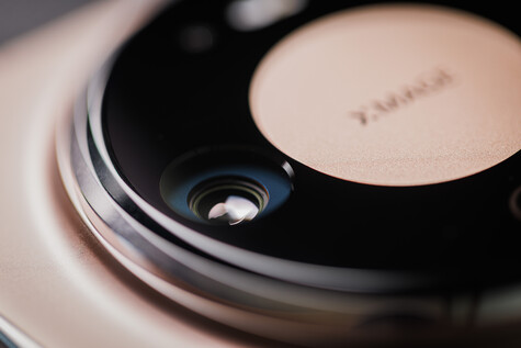 Close-up of a camera lens with visible glass elements and blue coating reflections.