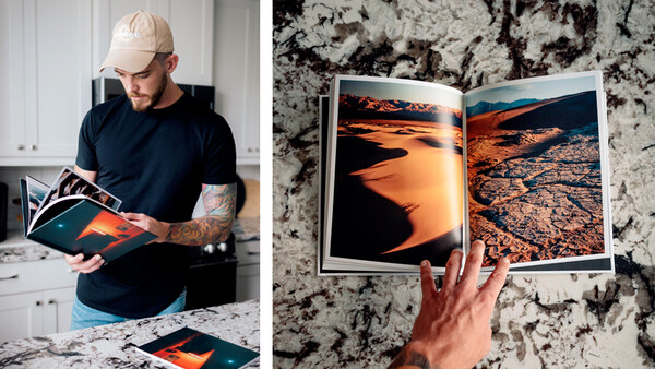 Photographer reviewing printed photo spreads of desert landscapes with warm orange tones.