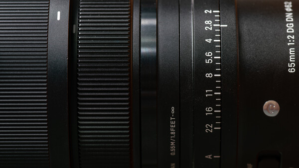Close-up view of a camera lens barrel showing aperture markings and focal length scale.
