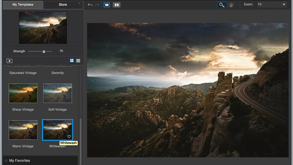 Mountain landscape with winding road at sunset, stormy sky with golden light breaking through clouds.
