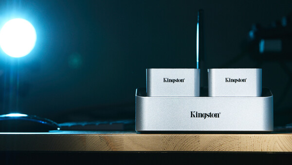 Kingston storage device dock with two external drives displayed against moody blue lighting.
