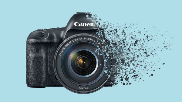 Canon EOS R5 mirrorless camera with 24-105mm lens against light blue background, right side fragmenting into particle effects.