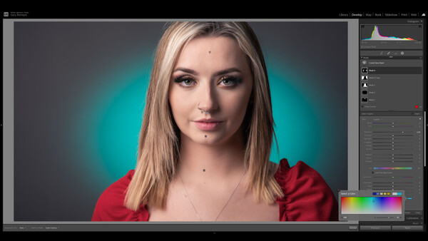 Portrait of a woman with long blonde hair wearing a red top against a teal gradient background.