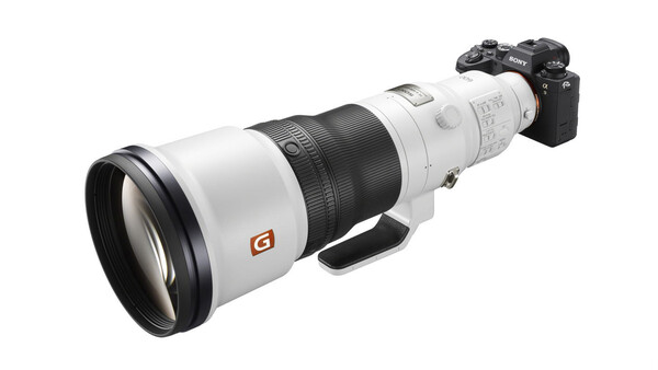 Sony mirrorless camera mounted with a large white telephoto lens featuring an orange G badge.