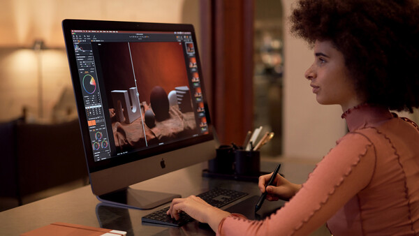 Photographer editing interior images on a desktop computer using professional editing software.