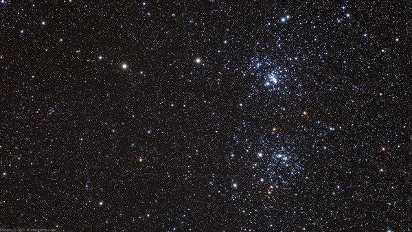 The Pleiades star cluster glowing against a dense field of surrounding stars in deep space.