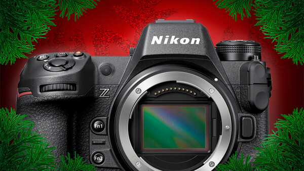 Nikon Z mirrorless camera with body cap removed, displayed against a red background with evergreen garland.