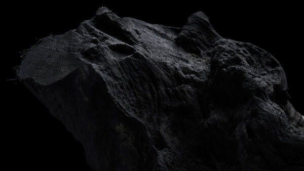 Dramatically lit dark rock formation against black background, showcasing rugged texture and angular peaks.