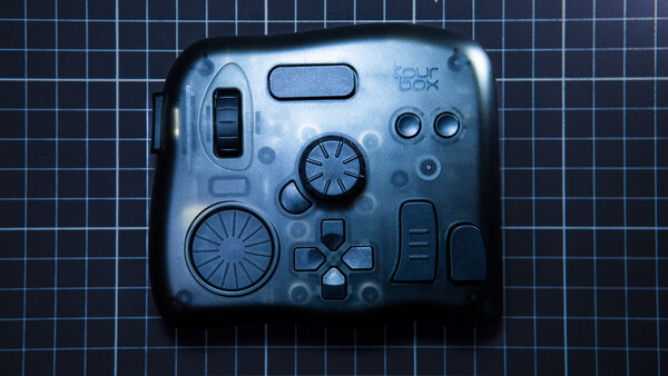 Flat lay of camera controls and mechanical components arranged on grid background.