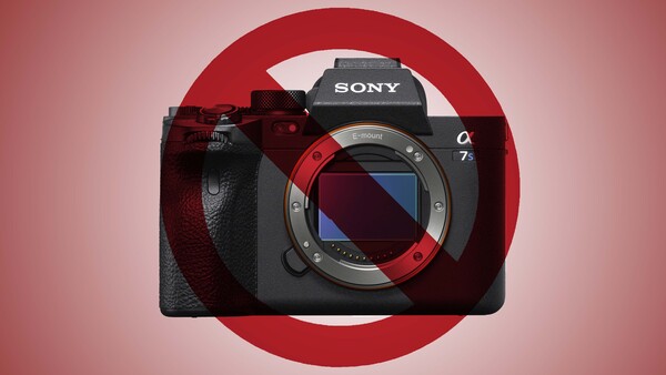 Sony a7 mirrorless camera body with red accent ring displayed against pink background.