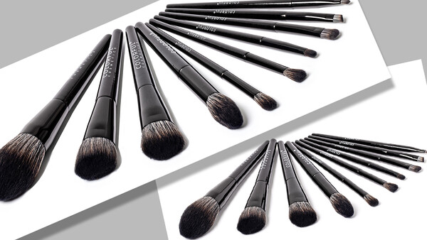 Two sets of professional makeup brushes arranged in curved rows against white paper.