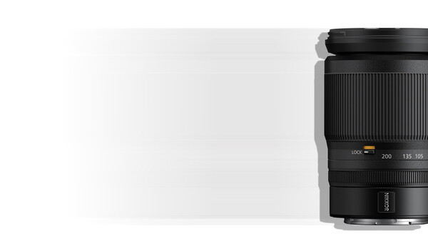 Black telephoto zoom lens with focal length markings visible on the barrel against a light background.