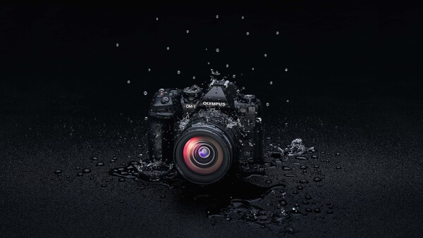 Olympus camera with water splashing around it against a dark background.