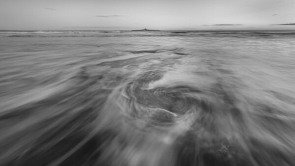 Swirling ocean water with long exposure motion blur creating spiral patterns across the frame.