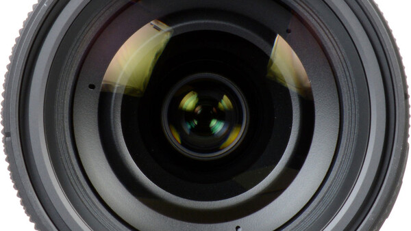 Front-facing view of a camera lens showing concentric glass elements and internal reflections.