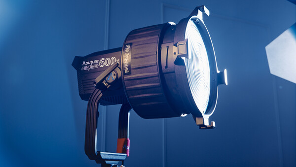 Aputure 600D Pro studio light mounted on a stand against a blue backdrop.