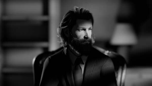 Bearded man in pinstriped suit jacket gazes to the side in black and white portrait.