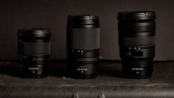 Three prime lenses arranged in order of focal length, displaying their specifications on the barrel.