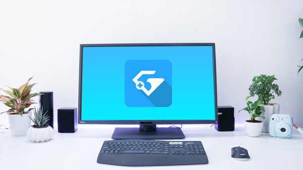 Desktop setup with monitor displaying blue icon app on clean white desk.
