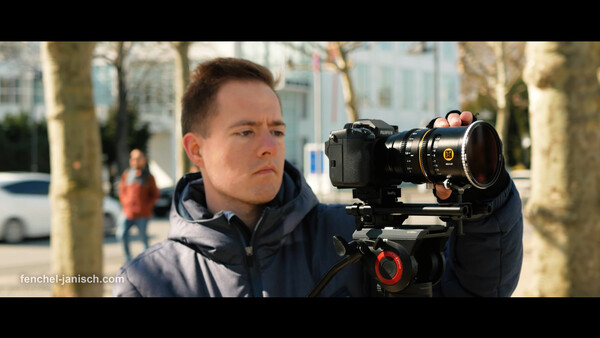 Cinematographer operating a cinema camera on a gimbal in an urban outdoor setting.