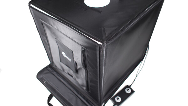Black fabric photography light tent with translucent panels and carrying case on wheels.
