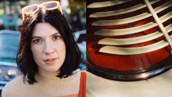 Woman with short dark hair and sunglasses on head, wearing beige ribbed sweater and red bag strap visible.