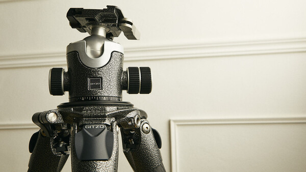 Professional ball head tripod mount with fluid friction control and panoramic adjustment capabilities against a neutral background.