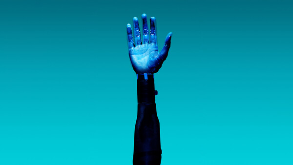 Illuminated hand raised against solid turquoise background with glowing blue light effect.