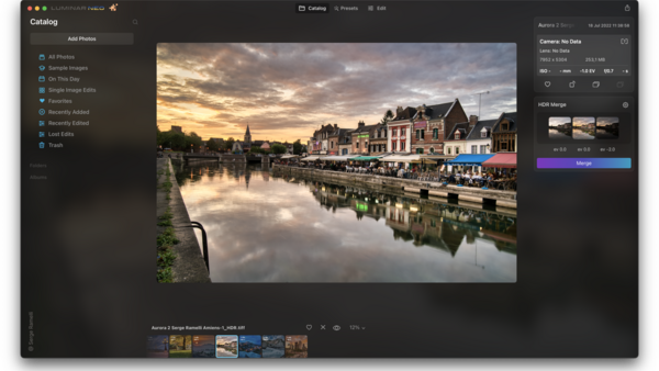 European riverside town at golden hour with historic architecture reflected in calm water.