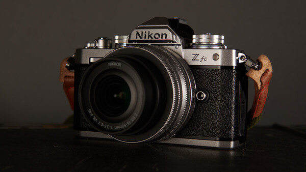 Nikon Zfc mirrorless camera with wood grip accessories, mounted with a standard lens.