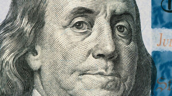 Engraved portrait of a man with long hair, rendered in fine parallel lines and crosshatching on currency.