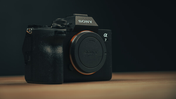 Sony a7 mirrorless camera body displayed against dark background on wooden surface.