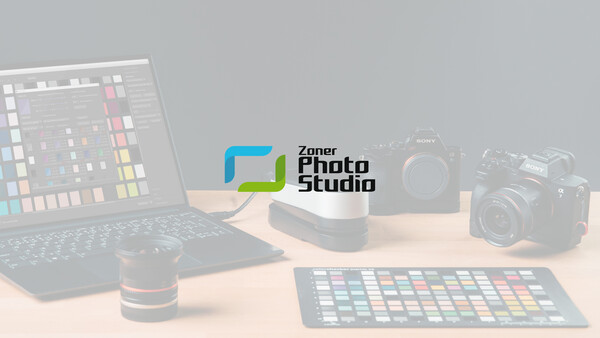 Zoner Photo Studio logo displayed on a studio desk setup with professional cameras and color reference tools.