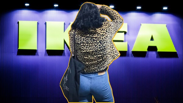 Woman in leopard print jacket and jeans posing against neon-lit signage with purple and green lighting.