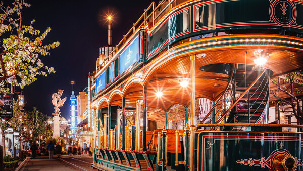Illuminated carousel with warm golden lights and ornate details at night on a city street.