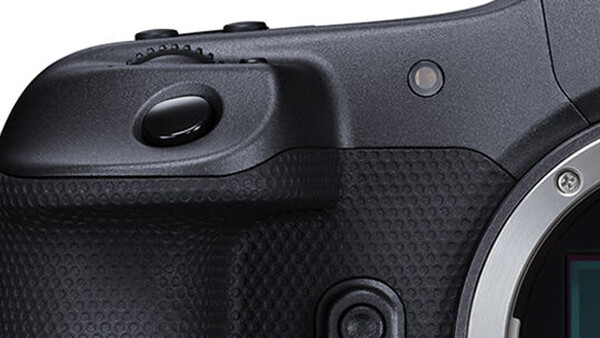 Close-up of a mirrorless camera body showing the grip, textured handhold area, and electronic viewfinder housing.