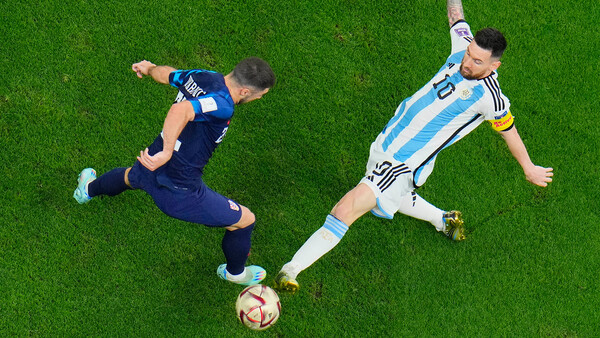 Overhead view of two soccer players competing for the ball on grass field.