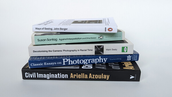 Stack of six photography and visual theory books arranged in a tilted pile against a white background.