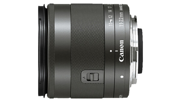 Canon EF-M 18-55mm f/3.5-5.6 IS STM lens with textured barrel and control buttons visible.