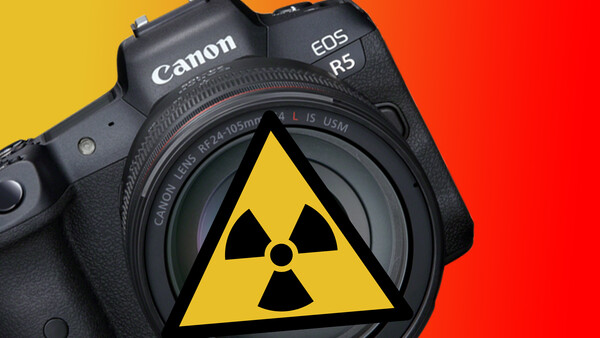 Canon EOS R5 mirrorless camera with a radiation hazard symbol displayed on its sensor against a yellow and red gradient background.