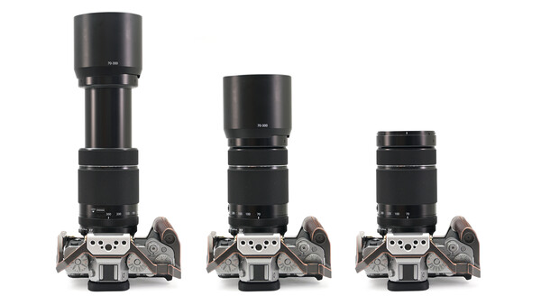 Three film camera bodies with progressively longer telephoto lenses mounted on top, arranged left to right in descending size order.