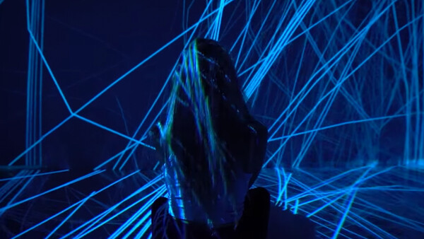 Silhouetted figure surrounded by intersecting blue neon lines in a digital environment.
