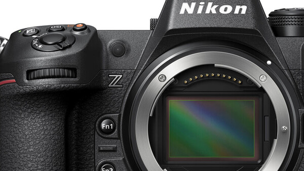 Nikon Z mirrorless camera with mount open, showing sensor with rainbow-colored dust spots.