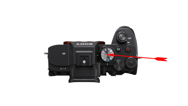 Top-down view of a Sony mirrorless camera with mode dial and control buttons highlighted.