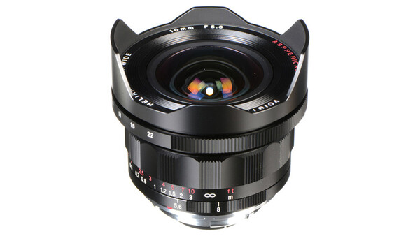 Wide-angle manual focus lens with prominent front optics and metal hood against white background.