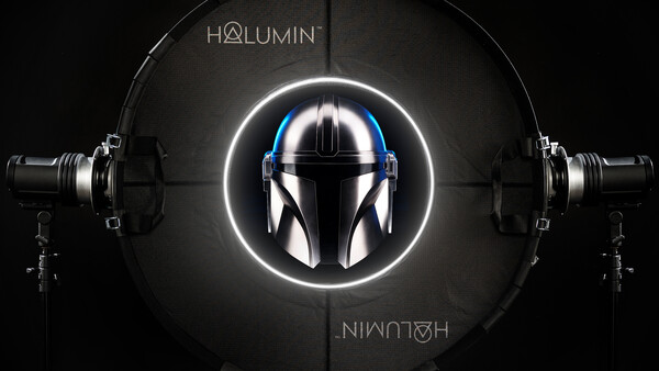 Mandalorian helmet centered in glowing white circle with professional lighting rigs on either side.