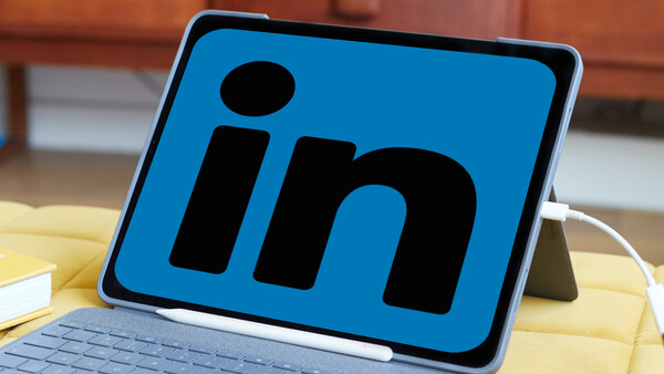 LinkedIn logo displayed on a tablet screen in a workspace setting.